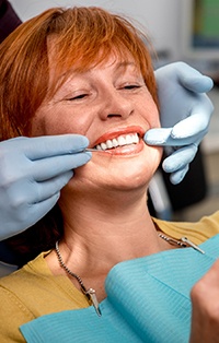 Female patient examining smile with dentist