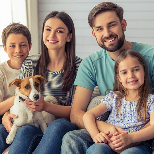 Happy family smiling on porch with dog