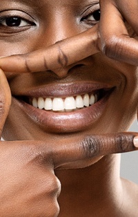 Woman making a square shape around her smile with hands