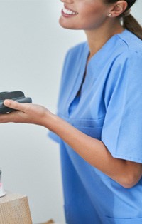 Smiling dental assistant taking credit card payment